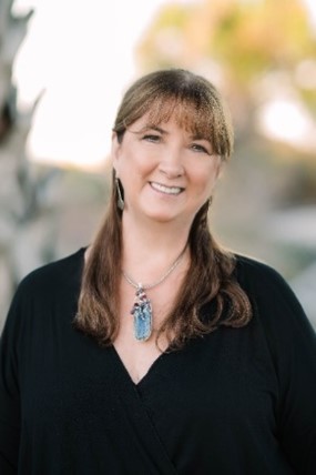 Picture of a white woman wearing a black V-neck blouse with a