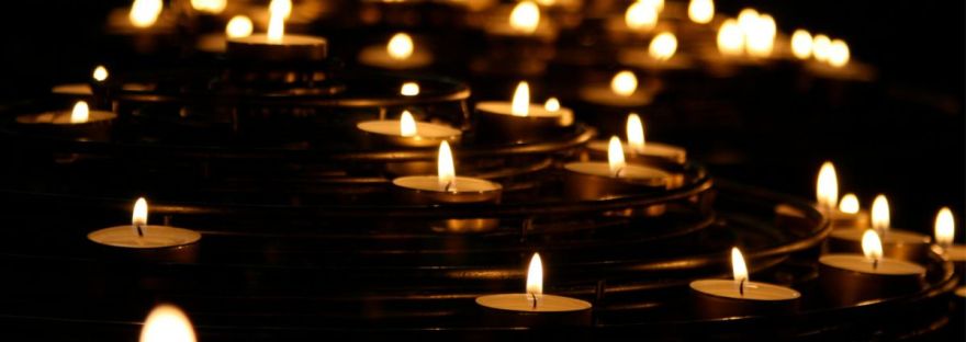 several warm tealight candles in a sea of blackness