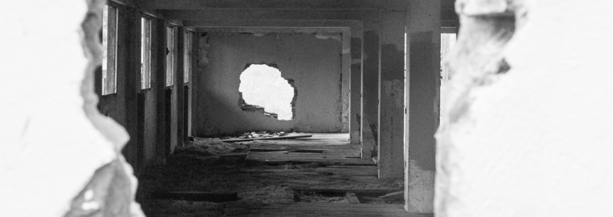 a black and white photograph of a broken wall with rubble